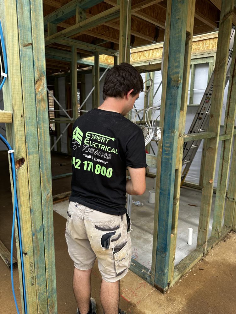 Wiring being run through a timber house frame